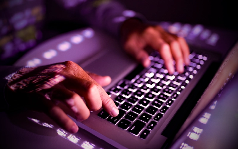 Man's hands typing on the keyboard of a laptop