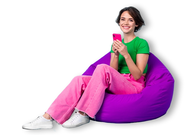 Young girl using a mobile phone sitting on a purple bean bag
